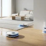 Vue d'un salon moderne et lumineux avec trois aspirateurs robots blancs : un nettoie le parquet, un autre le tapis, et le troisième est à sa station de recharge.