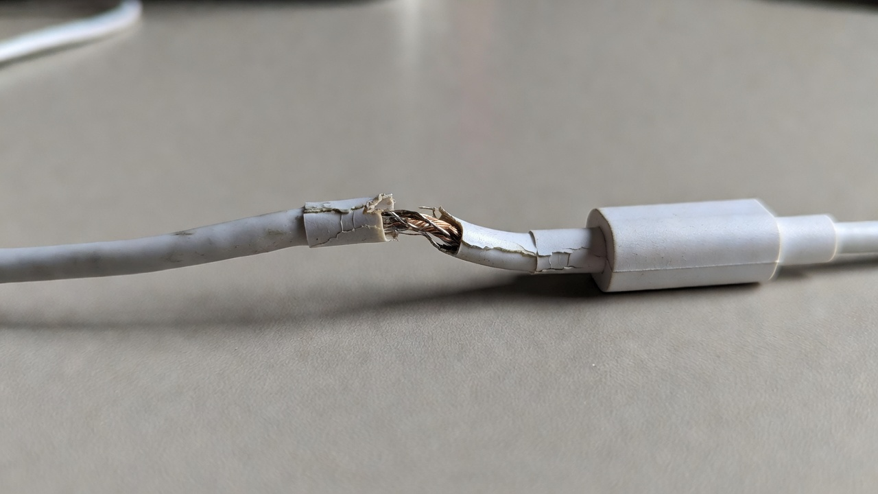 Câble de charge plié et usé près du connecteur, sans marque.